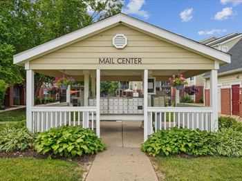 the mail center is in a small wooden building with a sidewalk